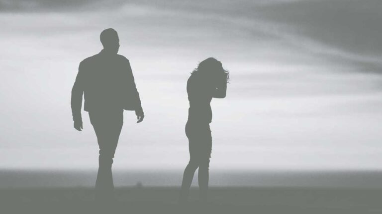 Silhouette of woman walking away from male partner